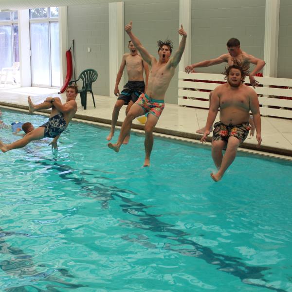 Boys jumping into the pool